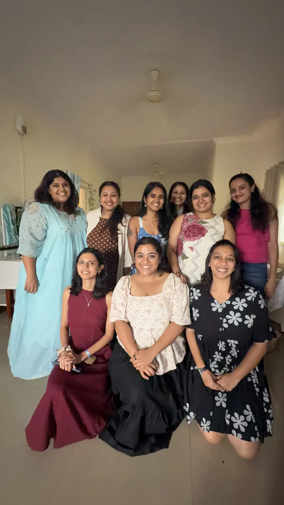 Nine smiling women posing together in the living room after the Bridgerton supper club